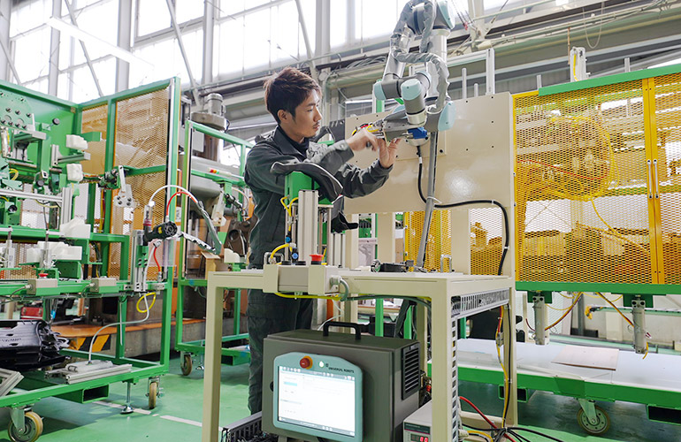 木曽川工場内で協働ロボットの調整作業中の写真
